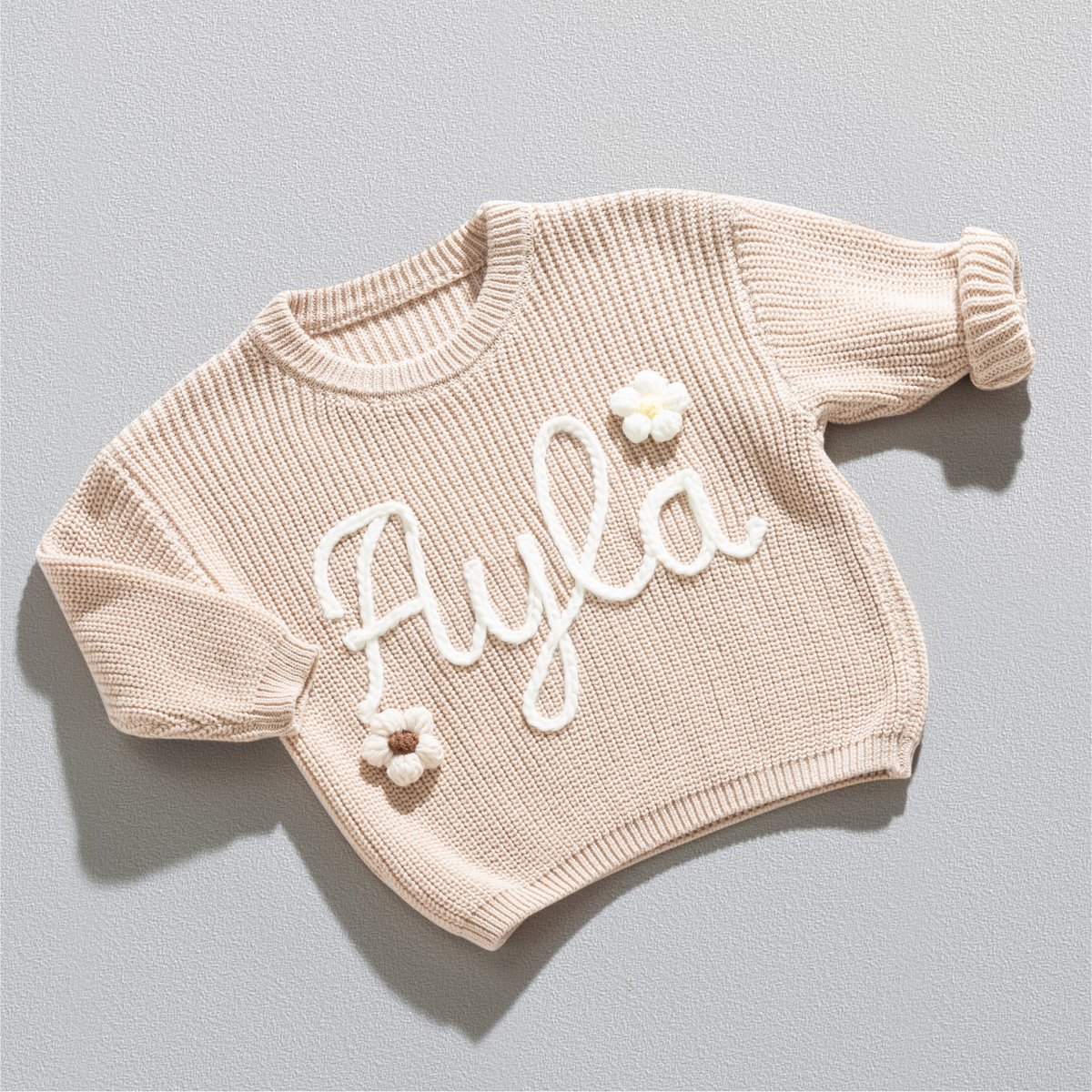 Personalisierter Strickpullover in Beige mit dem Namen Ayla, handgestickt in Off-White